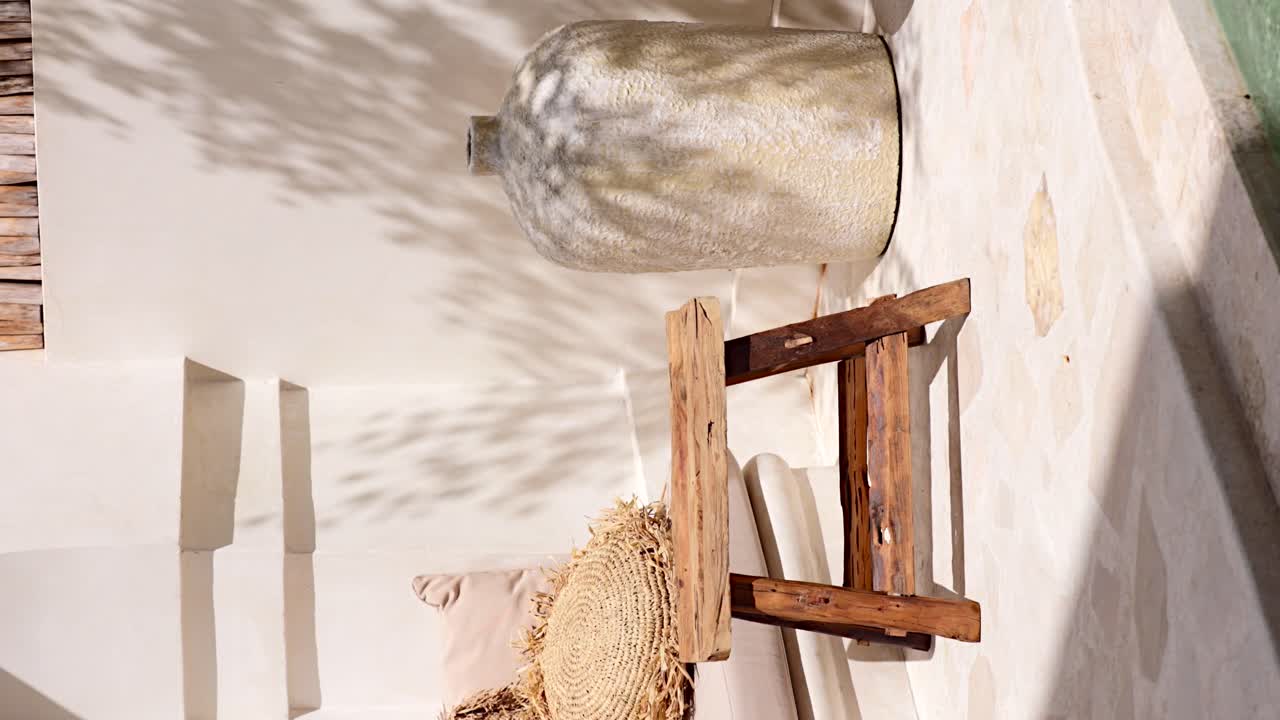 - patio de terraza de patio vertical decorado en estilo balinés con muebles hechos a mano hechos de madera antigua y grandes jarrones de cerámica vintage en la esquina