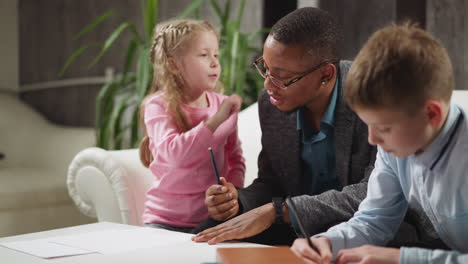 girl pupil touches black man ear learning body parts names