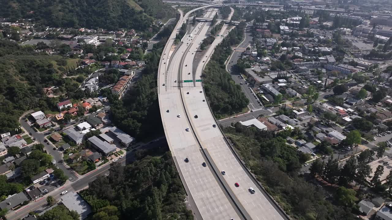 Los Angeles, California interstate freeway through the foothills and suburbs - aerial flyover