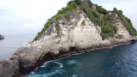 limestone seamount rock formation, atuh beach nusa penida island indonesia, aerial establish