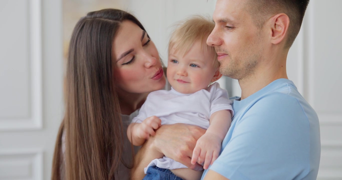 Genitori amorevoli che baciano il loro adorabile bambino