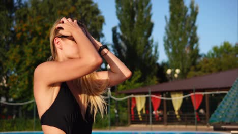 woman in a black swimsuit by the pool