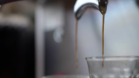 Close-up-of-cup-of-coffee-from-coffee-machine-in-cafe