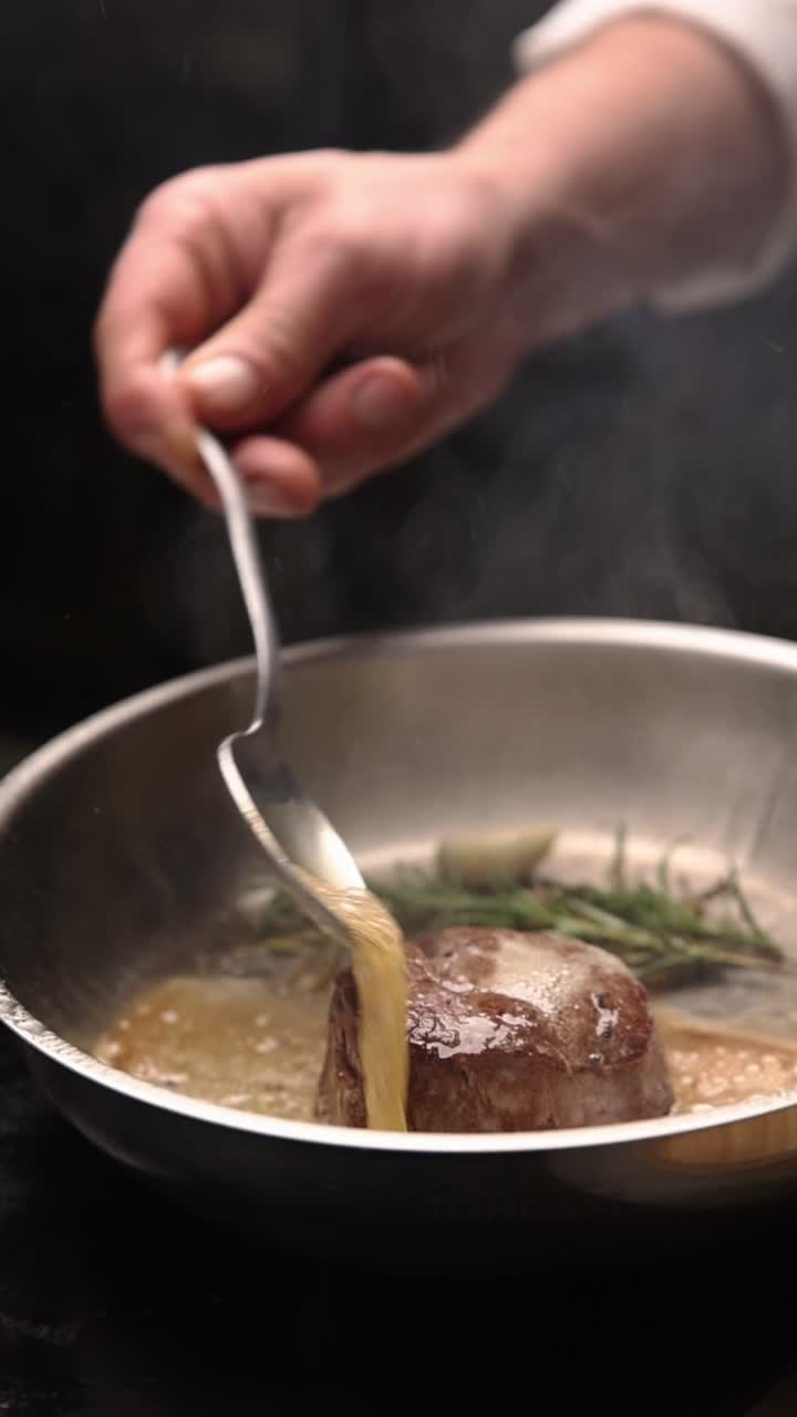 Chef Basting Steak with Butter and Herbs in a Hot Pan
