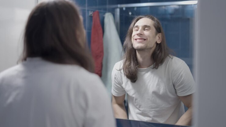 hombre mirándose a sí mismo en el espejo del baño