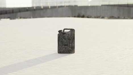 canister stands alone in a sandy landscape under bright daylight
