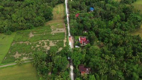 Top-View-Of-Idyllic-Village-By-The-Road-Between-Lush-Vegetation-In-San-Isidro,-Saint-Bernard,-Southern-Leyte-in-the-Philippines---Aerial-Drone-Shot