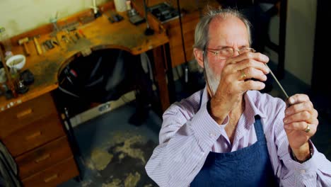 goldsmith examining metal in workshop 4k