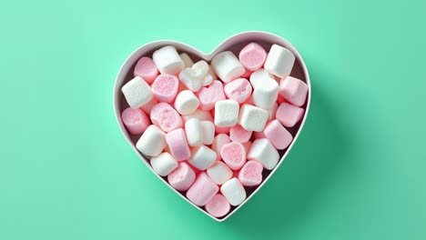 heart-shaped container filled with pink and white marshmallows