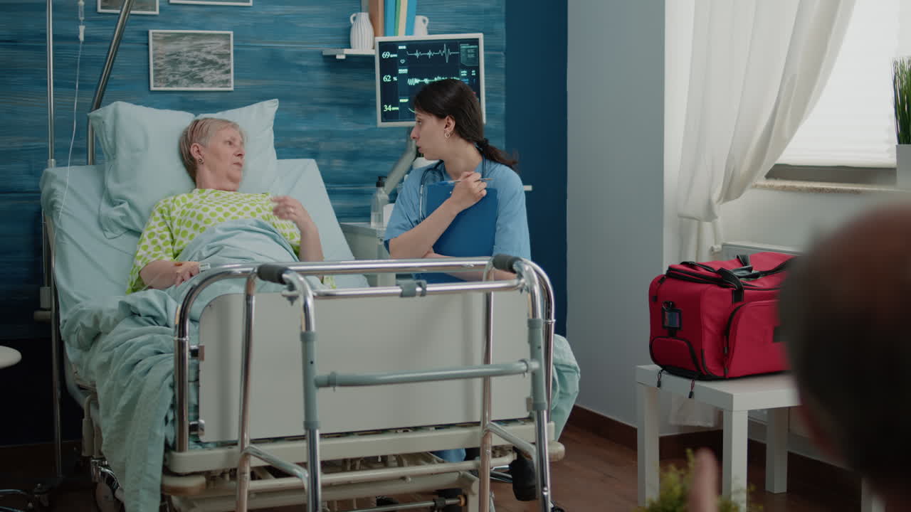 Nurse talking to retired patient with sickness in nursing home