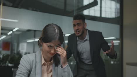 discriminación de género en la oficina. retrato de una joven empleada desesperada llorando, su colega enojada gritándole