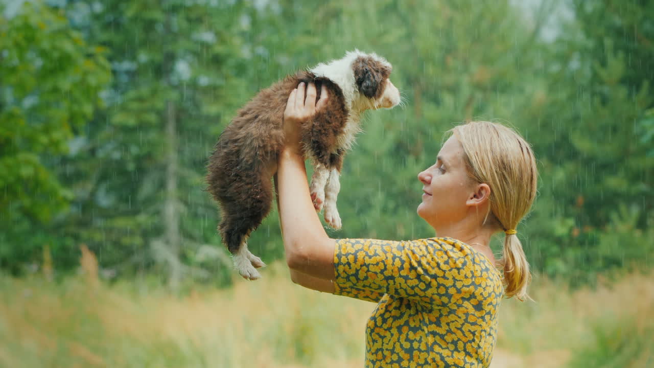 여름 따뜻한 비에 강아지를 품에 안고 젖은 행복한 여자 인생의 잊을 수 없는 순간