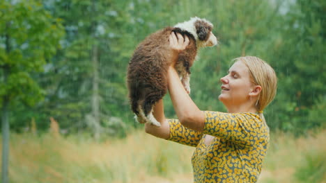 wet happy woman with a puppy in her arms in the summer warm rain unforgettable moments of life