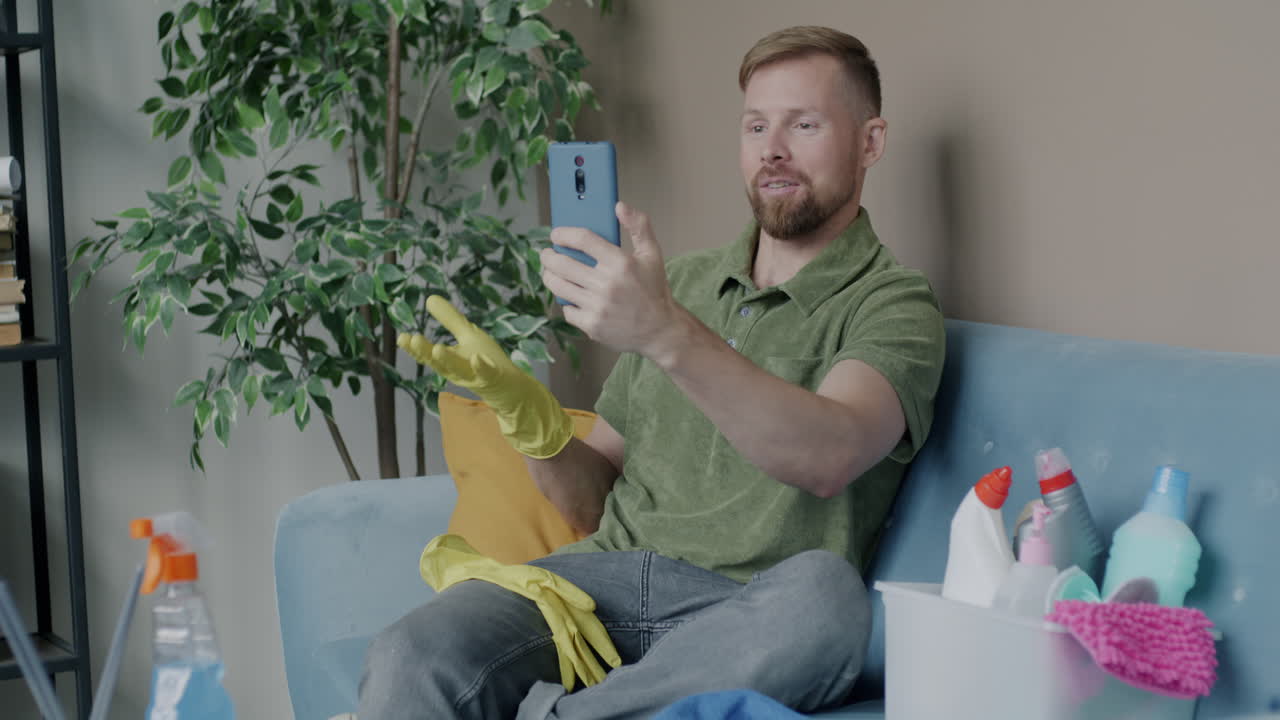 Man video chatting while cleaning