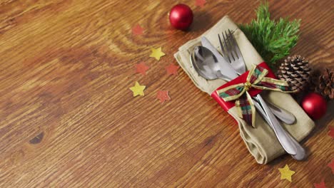 Video-of-christmas-decorations-with-cutlery-and-copy-space-on-wooden-background