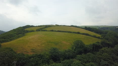 Cornwall-rolling-hills-and-farm-fields-on-overcast-day,-United-Kingdom,-aerial