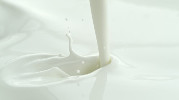 Pouring Milk into White Creamy Liquid Making a Splash and Wave in Macro and Slow Motion