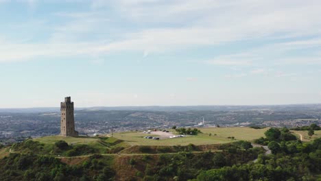 drone shot of castle hill aka victoria tower in huddersfield with the town in the background on the right