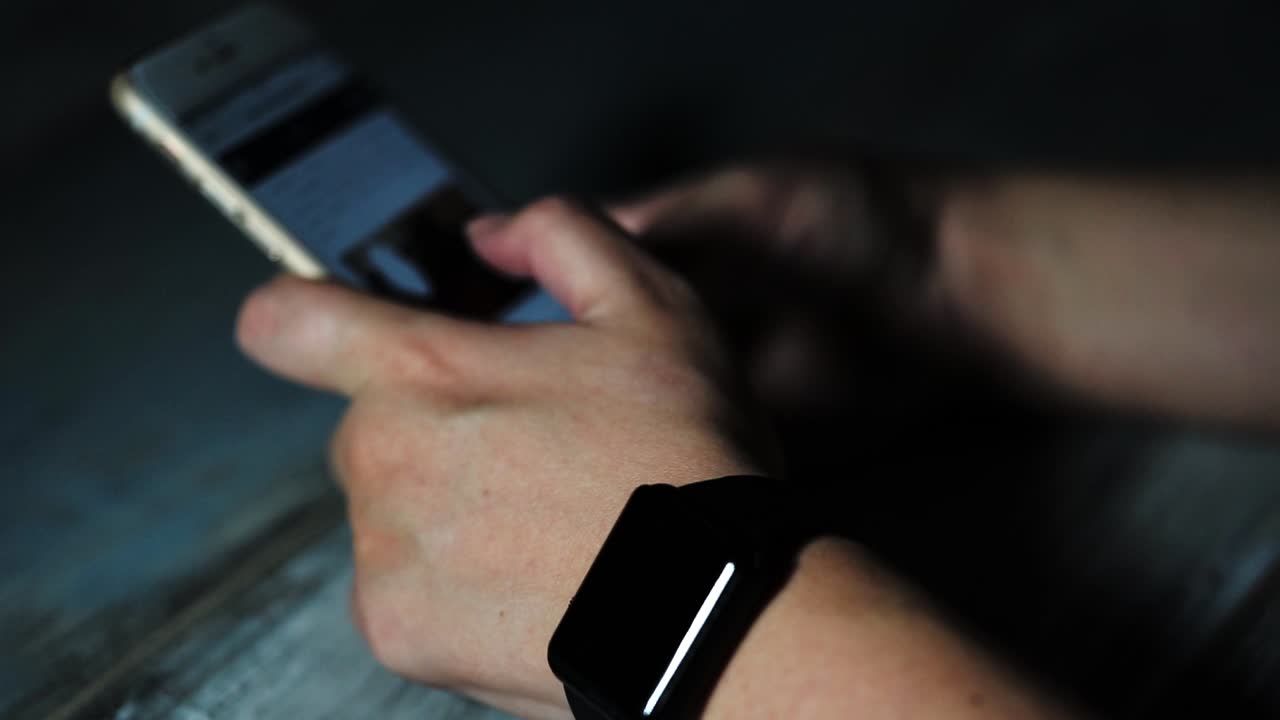 persona que utiliza un teléfono inteligente y un reloj inteligente