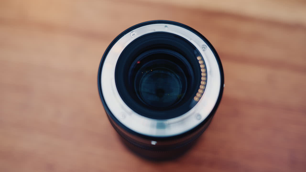 Nahaufnahme eines Kameraobjektivs in der Hand mit weichem Bokeh im Hintergrund