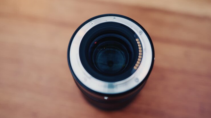 Nahaufnahme eines Kameraobjektivs in der Hand mit weichem Bokeh im Hintergrund