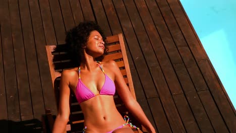 Gorgeous-woman-in-pink-bikini-relaxing-by-swimming-pool