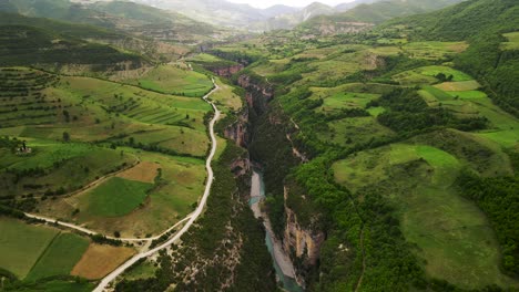 aerial scenic drone shot of the osum canyon in albania with a river flowing through the dense green foliage and forest