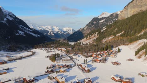 pequeña ciudad en el valle de la montaña alpina con nieve iluminada por la luz del sol de invierno