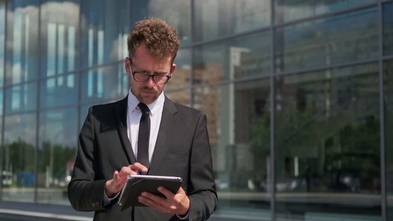 Empresário usando tablet em frente a um edifício moderno