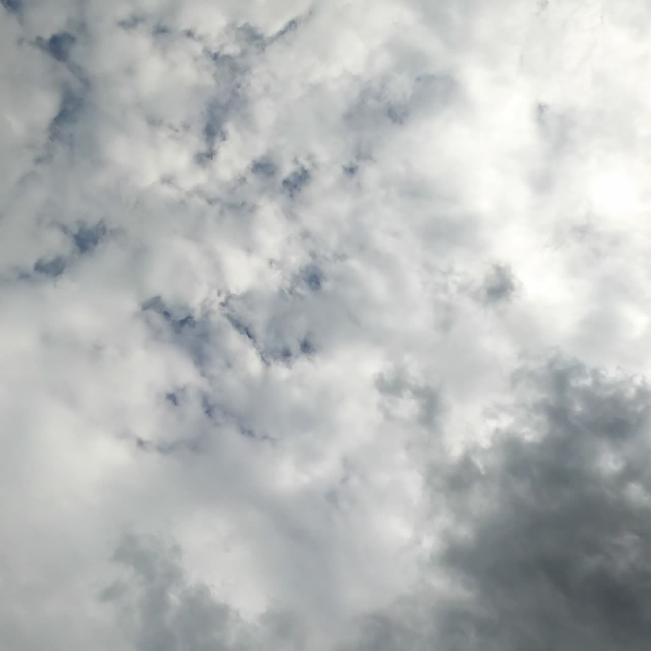 Heavy white and gray clouds covering the sky. Low angle perspective timelapse of moving clouds