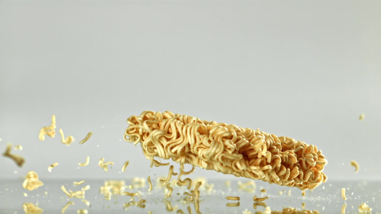 Blocco di noodle ramen istantanei che cade e si rompe al rallentatore