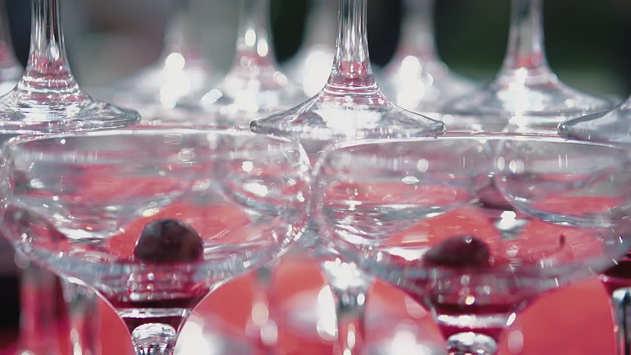 Glaspyramide med et kirsebær i hvert glas i slowmotion.