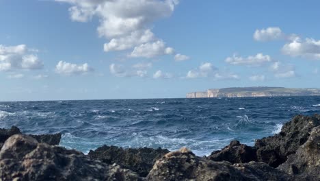 sea waves hitting rocky malta coastline