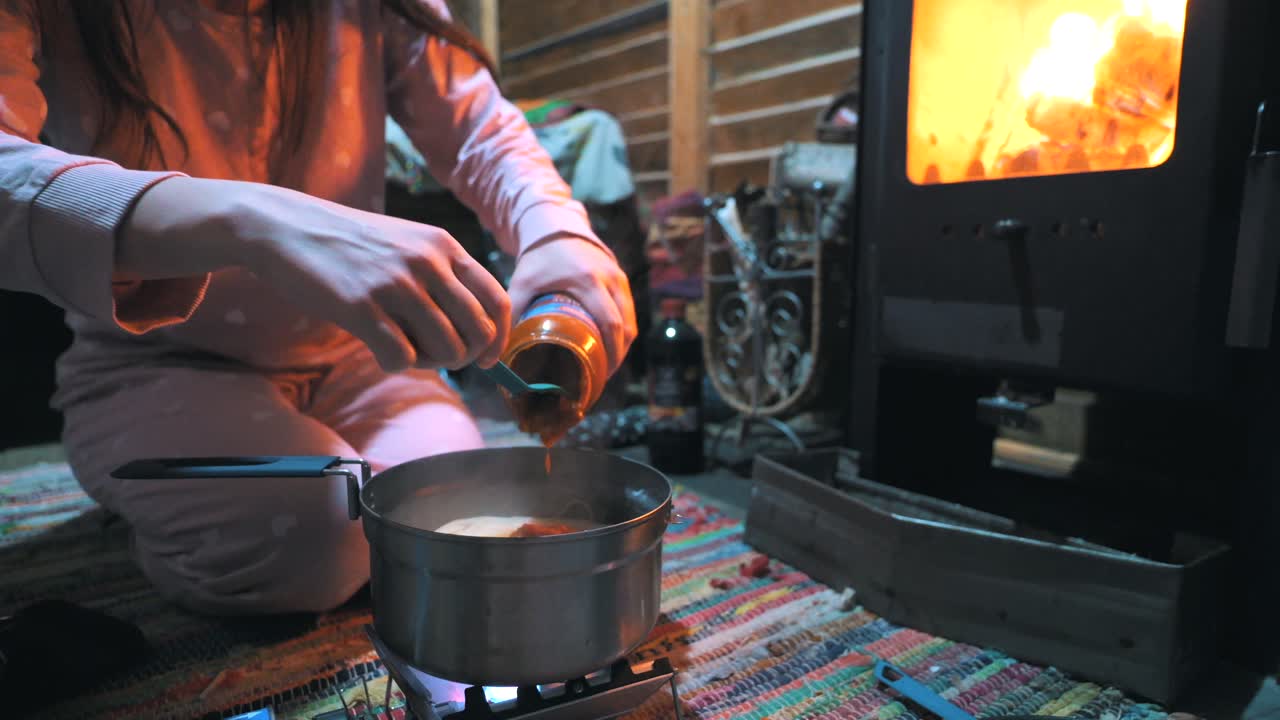 cocinar pasta con una estufa de gas portátil en una cabaña en la naturaleza, al aire libre, acampar