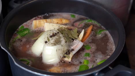 topf mit knochenbrühe, gemüse und gewürze, langsam in einem großen topf kochen