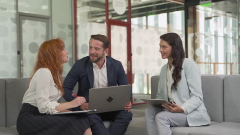 work team composed of two women and a man in a meeting put things in common in a relaxed atmosphere 1