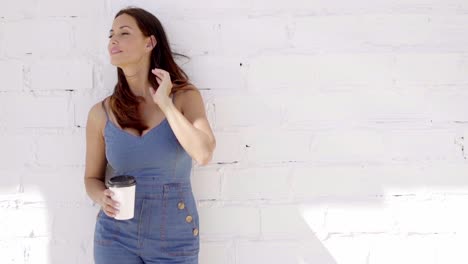 Young-woman-enjoying-a-cup-of-takeaway-coffee