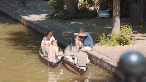 tourists sitting in the canoe at the riverbank during sunny day