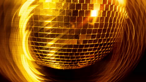 a spinning gold mirror ball in night club