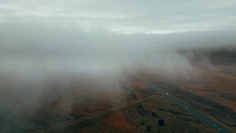 large bare rocky cliffs with small dense white fog and grey clouds