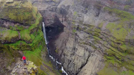 Schluchtwasserfall-Stationärer-Schuss-Von-Wanderer-Mit-Roter-Jacke,-Der-Die-Aussicht-Auf-Die-Grüne-Schlucht-Bewundert