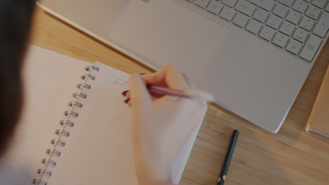 Student studying with laptop and notebook