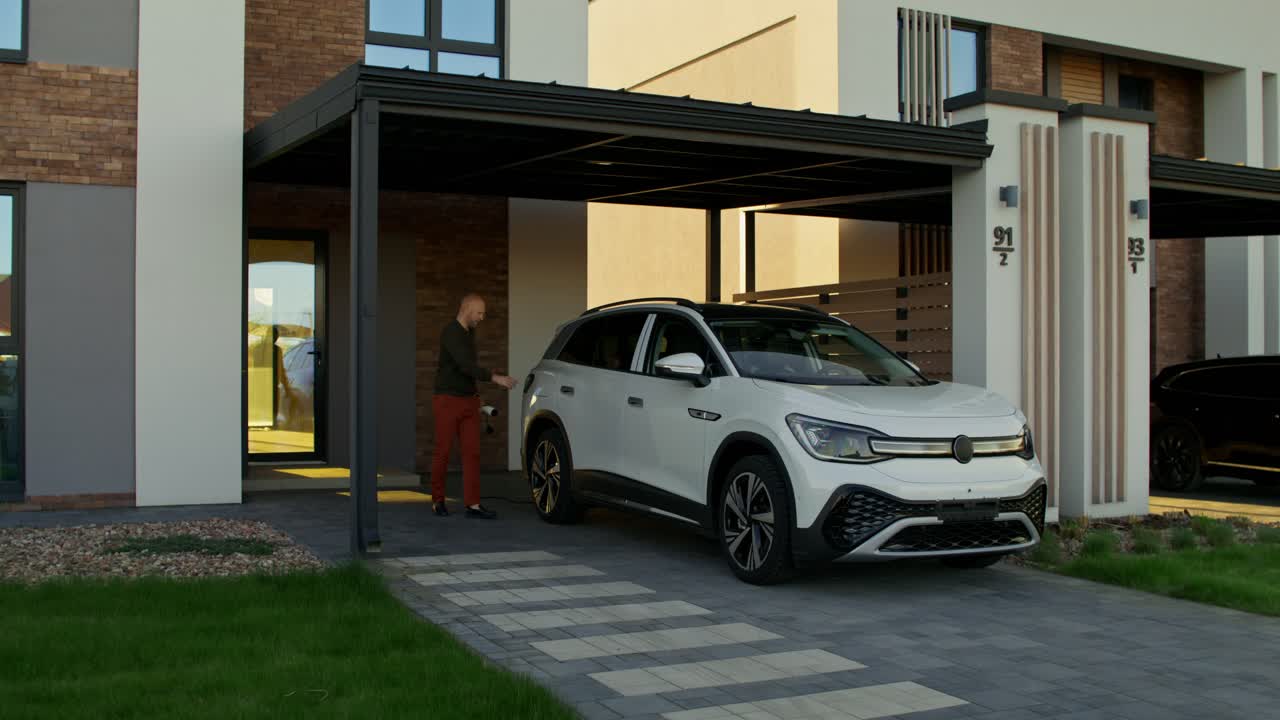 hombre cargando vehículo eléctrico en casa