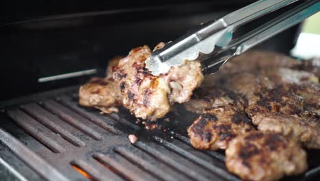 el chef voltea la carne en la barbacoa
