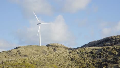 un solo aerogenerador girando sobre una colina