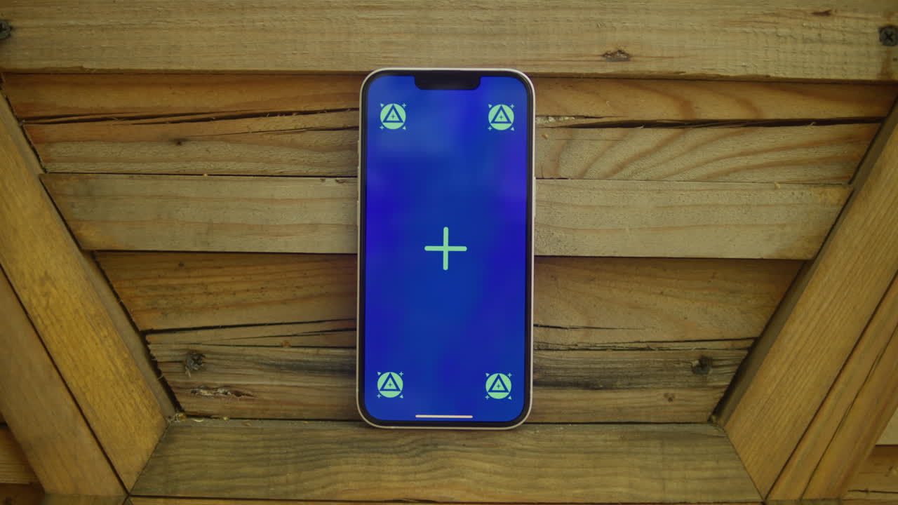 Phone with chroma key screen on wooden background close-up. Green screen on smart phone. Nature