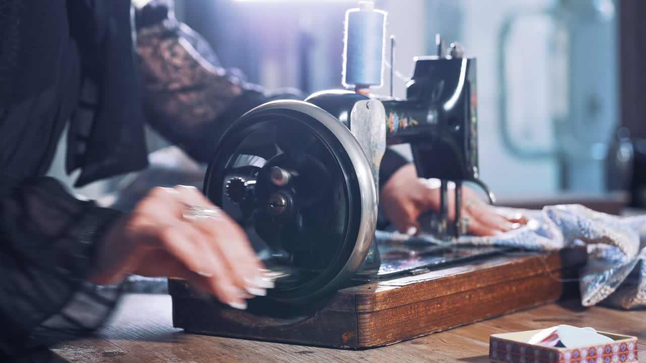 Seamstress with old sewing machine. Close up of seamstress working on sewing machine