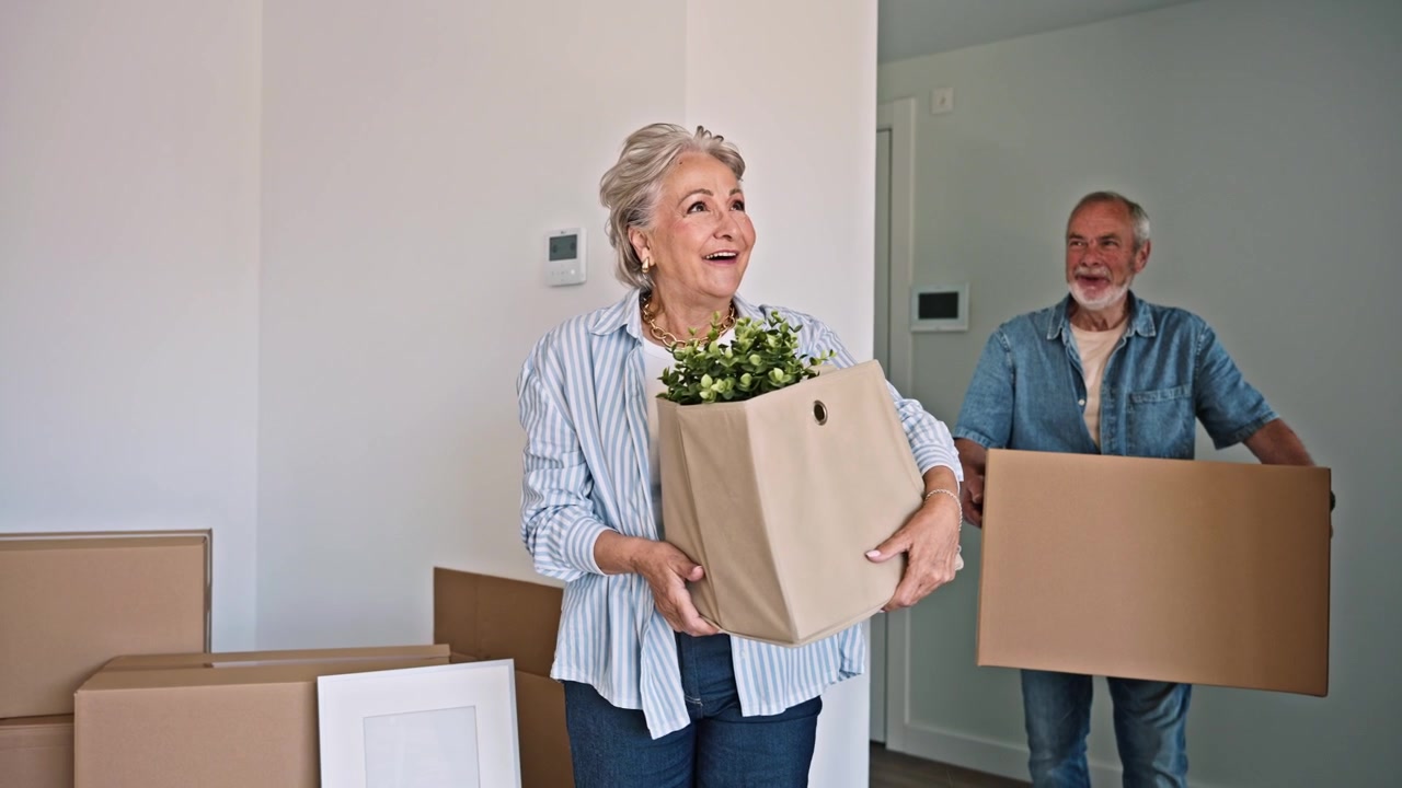 Happy Senior Couple Moving into Their New Home with Boxes