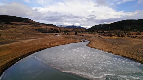 drone aerial view flying over river stream with dry yellow riverbanks in colorado countryside near sapphire point dillon reservoir