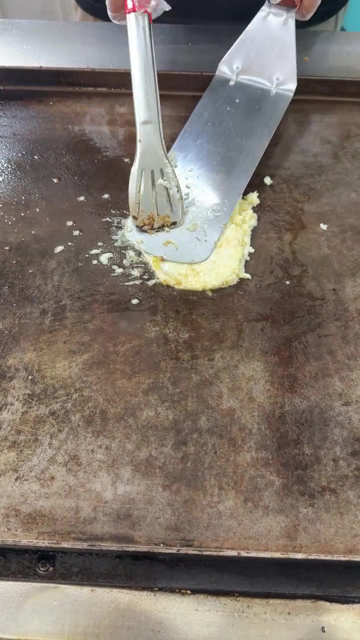 Chef Cooking Scrambled Eggs on a Flat Top Grill